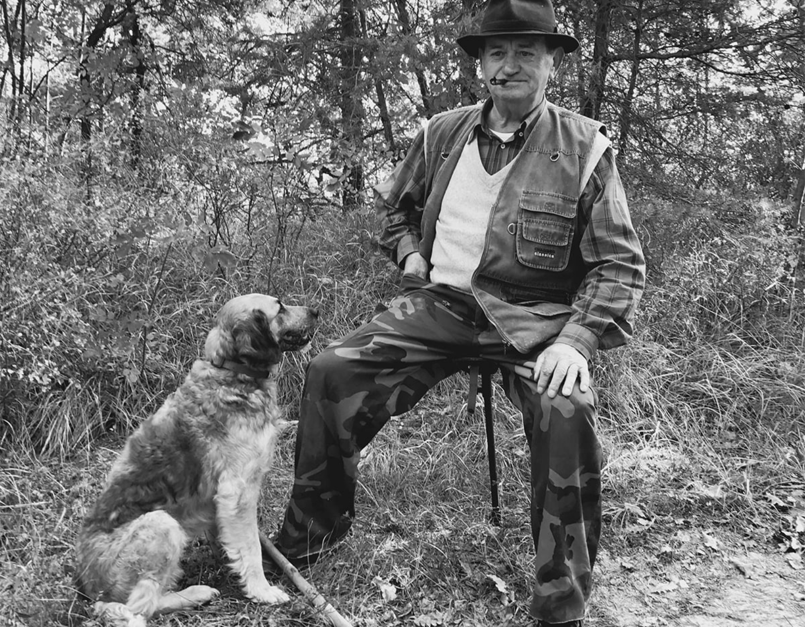 activities_truffle-hunting Old man sitting on a chair outside with a dog